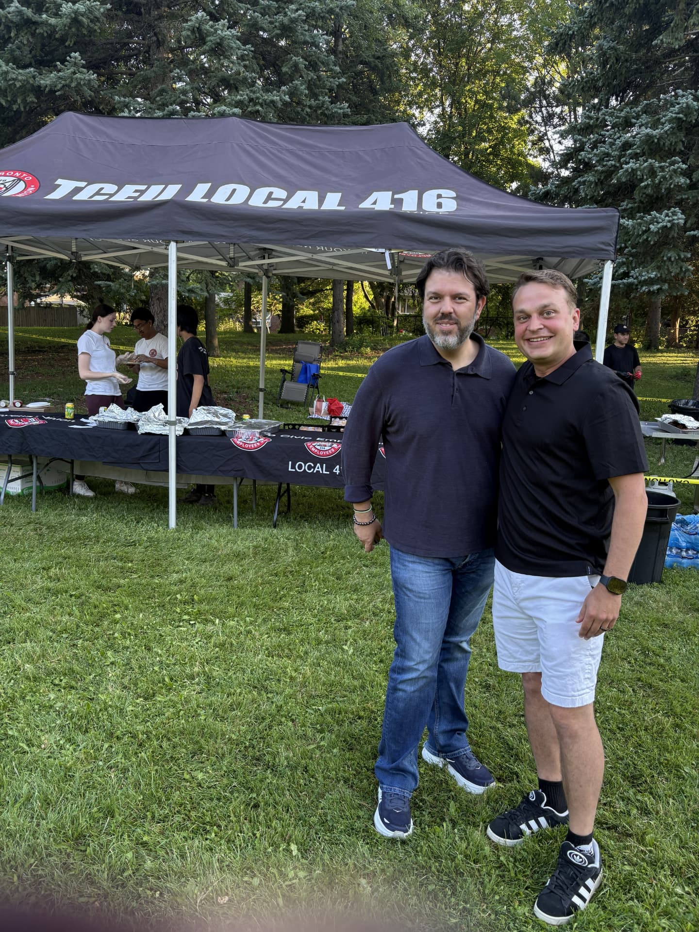 Christopher Mammoliti with a community representative at an outdoor community event